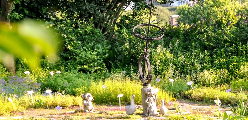 Bunter Kräutergarten geschmückt mit Dekostatuen
