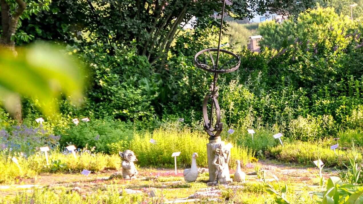 Bunter Kräutergarten geschmückt mit Dekostatuen
